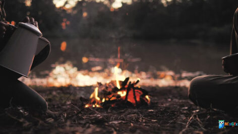 دانلود استوک ویدیو در حال ریختن نوشیدنی گرم در اطراف آتش